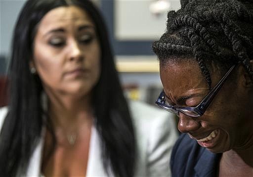 In this July 19, 2016 photo, Breaion King is overcome with emotion as she describes being pulled from her car and thrown to the ground by an Austin police officer during a traffic stop in 2015, during an interview at her attorney, Erica Grigg's office in Austin, Texas. 