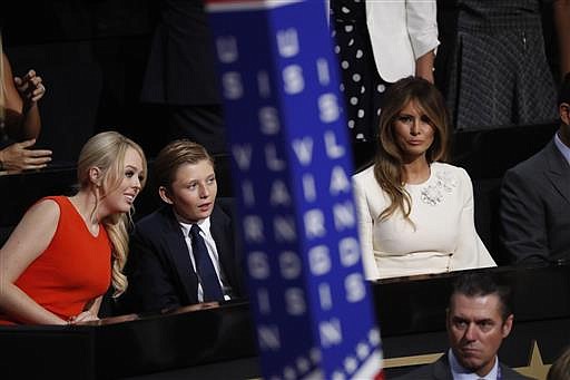 Barron Trump, center, son of Donald and Melania Trump, talks to Tiffany Trump as Melania Trump sits at right during the final day of the Republican National Convention in Cleveland, Thursday, July 21, 2016.