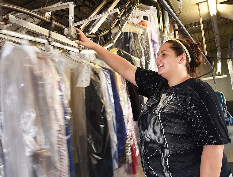 Peggy Ortiz retrieves a customer's dry cleaning at Capital City Cleaners on 104 E. McCarty St. Thursday afternoon. Although this location does not have the steam cleaning or presses, it still is very hot inside the small building, which does not have air conditioning.