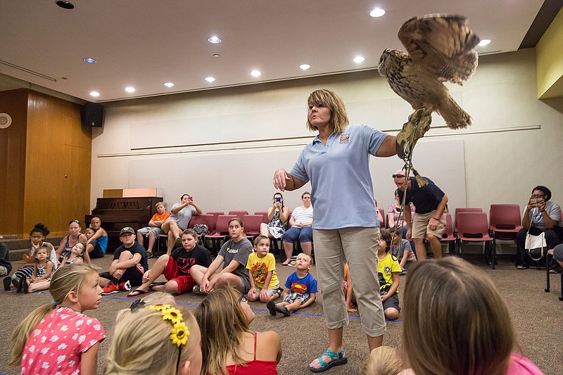 Shawna Adams introduces Elliot, a Eurasian eagle-owl, to children who accomplished their summer reading goals at the Texarkana Public Library. Adams works for Natural History Education Co. of the Midsouth and tours the region educating children about exotic animals. When Adams moves her arm, Elliot opens his wings to regain balance. 