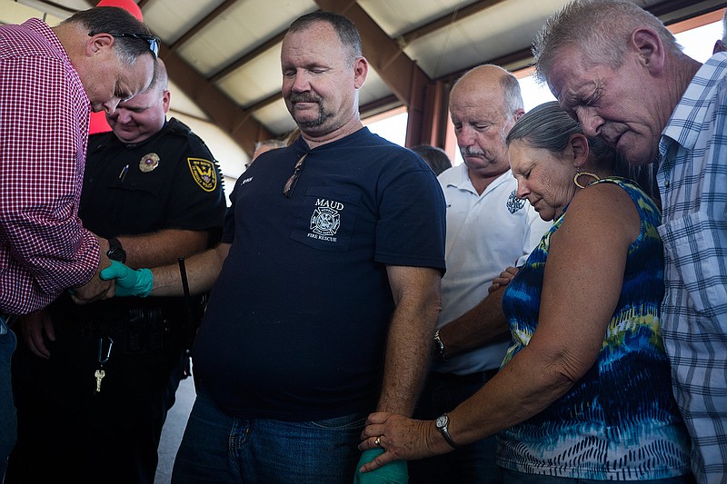 Maud, Texas, Fire & Rescue Chief John Nichols is surrounded by Bowie County residents Friday, July 23, 2016 during a public servant prayer rally for local law enforcement, fire departments and first responders at the Trailhead Pavilion in New Boston, Texas. 