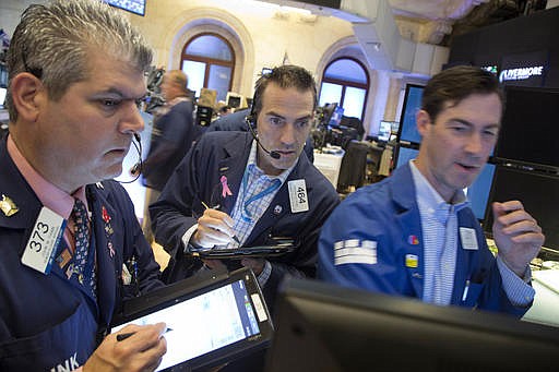 John McNierney, right, trading GE stock for Citadel Securities, updates John Panin, left, and Greg Rowe, center, with the stock's price at the New York Stock Exchange, Friday, July 22, 2016.