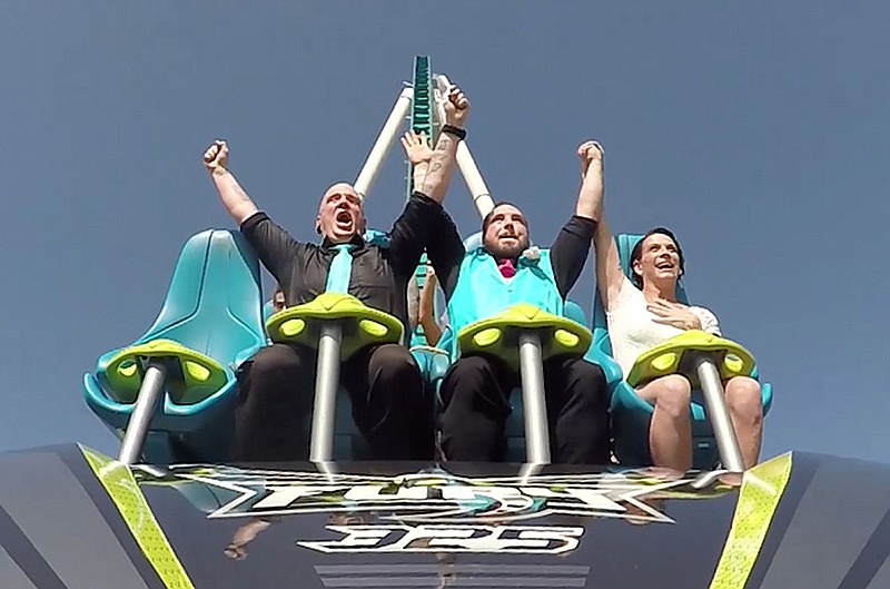 From left, Rev. Robert Hamilton and bride and groom, James and Cortni Music, take the plunge after exchanging vows on the Fury 325 at Carowinds July 14, 2016 in Charlotte, N.C. 