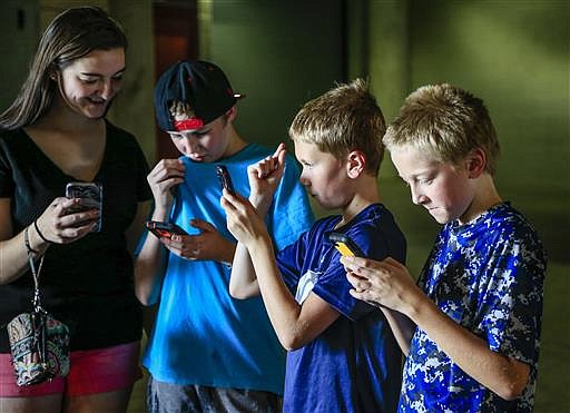 In this Thursday, July 14, 2016, file photo, youngsters play during a "Pokemon Go" event at Memorial Stadium in Lincoln, Neb. Pokemon Go's origins are as peculiar as any of the creatures inhabiting the game. 