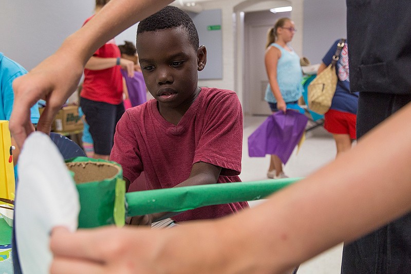 Kamarion Hudson, 7, finishes assembling an elephant with the help of Sara Jayne Burroughs on Saturday, July 23, 2016 at the Texarkana Regional Arts and Humanities Center. TRAHC hosts free Drop-In Art Workshop five times a year.