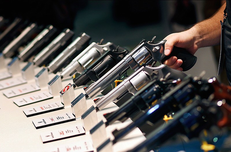 In this Jan. 19, 2016 file photo, handguns are displayed at the Smith & Wesson booth at the Shooting, Hunting and Outdoor Trade Show in Las Vegas. Nearly two-thirds of Americans expressed support for stricter gun laws, according to an Associated Press-GfK poll released Saturday, July 23, 2016. A majority of poll respondents oppose banning handguns.