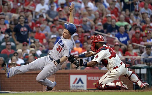 Los Angeles Dodgers' Joc Pederson, left, is tagged out at home by St. Louis Cardinals catcher Alberto Rosario during the sixth inning of a baseball game Saturday, July 23, 2016, in St. Louis.