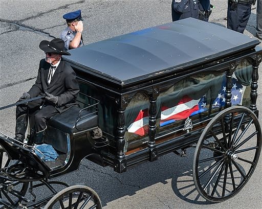 A horse drawn carriage pulls the casket of slain East Baton Rouge Sheriff Deputy Brad Garafola Saturday, July 23, 2016. Garafola and two Baton Rouge police officers were killed outside a convenience store less than a mile from police headquarters. (Scott Clause/The Daily Advertiser via AP)