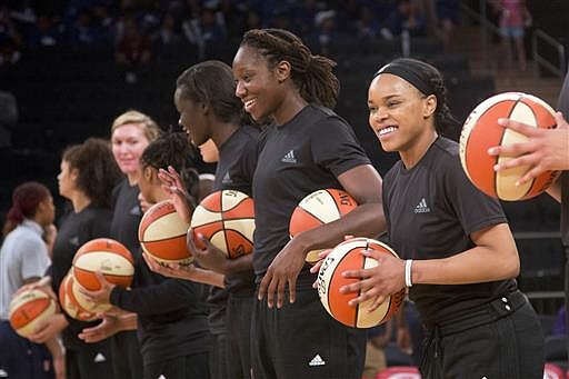 Members of the New York Liberty basketball team await the start of a game against the Atlanta Dream, Wednesday, July 13, 2016 in New York. Between the Black Lives Matter movement, the Orlando shooting and the LGBT community, more WNBA players have been taking active roles in expressing their views on social issues. In the midst of "Camp Day" at the New York Liberty's mid-morning game Wednesday, Liberty players stood in solidarity as they donned all-black warmups in support of the Black Lives Matter movement.