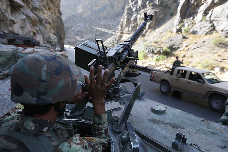 In this Tuesday, July 19, 2016 photo, an Afghan soldier greeting to other soldier in Kabul-Jalalabad highway on the outskirts of Kabul, Afghanistan. After two years of heavy casualties, the Afghan military is trying to retake the initiative in the war against militants with a new offensive next week, an assault that will see American troops back working more closely with Afghan soldiers. 