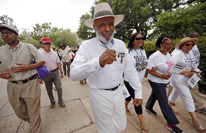 In this June 25, 2016 photo, civil rights pioneer James Meredith, center, and others walk through downtown Jackson, Miss., to the state Capitol, as part of a 50th commemoration of his march from Memphis to Jackson to encourage black people to overcome a fear of violence and to encourage them to register to vote. Along the way, he was shot and wounded, causing several groups and hundreds of marchers, including the Rev. Martin Luther King Jr., to take up the cause and help him finish the march to the Capitol. 