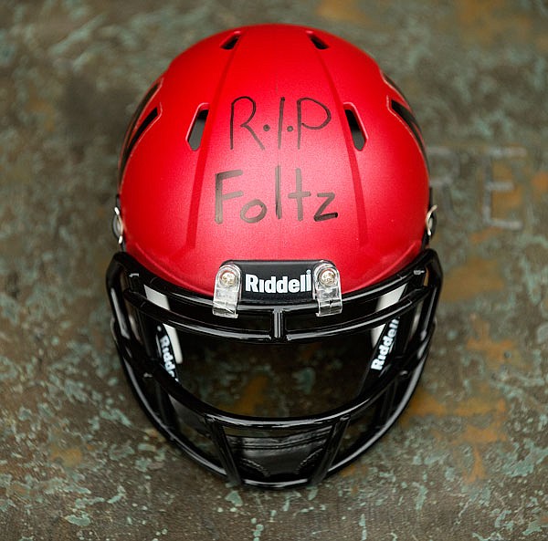 A Nebraska mini-football helmet inscribed "RIP Foltz," for Nebraska punter Sam Foltz is seen during a vigil for Foltz on Sunday in Lincoln, Neb. Foltz and former Michigan State punter Mike Sadler died in a car crash in Wisconsin late Saturday night after working at a kicking clinic, a sheriff's department official said Sunday. LSU kicker Colby Delahoussaye was injured in the crash.