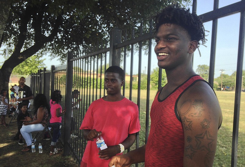 In this Saturday, July 16, 2016 photo, brothers Montrell White, 22, left, and Edwin White, 18, visit their childhood neighborhood for a potluck organized by young civil rights activists in the Estell Village subsidized apartment complex in the Highland Hills area of Dallas. The Whites say the neighborhood has been overrun with drugs and guns since they were kids. A rag tag group of young activists in this city have tried to raise awareness about the geographical segregation and unequal access to opportunities that continue to dog this city of 1.3 million people. 