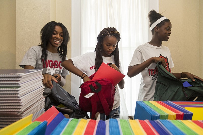 Jayda Griffin, Taylor Wilkerson and Lois Wimsatt pack backpacks with school supplies Monday at The Healing Place in Texarkana, Ark.. The backpacks will be given out on a first-come, first-serve basis from 10 a.m. to 1 p.m. Aug. 6  during the Back to School Empowerment Bash at The Healing Place. 