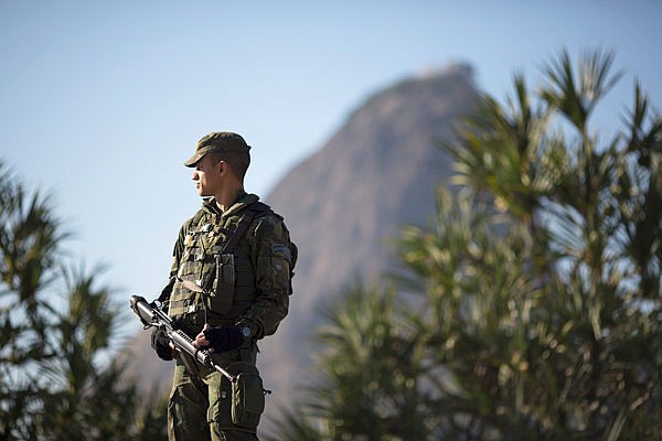 With Sugar Loaf mountain in the background, a soldier patrols near Botafogo beach Sunday in Rio de Janeiro. Security has emerged as the top concern during the Olympics, which will kick off on Aug. 5.