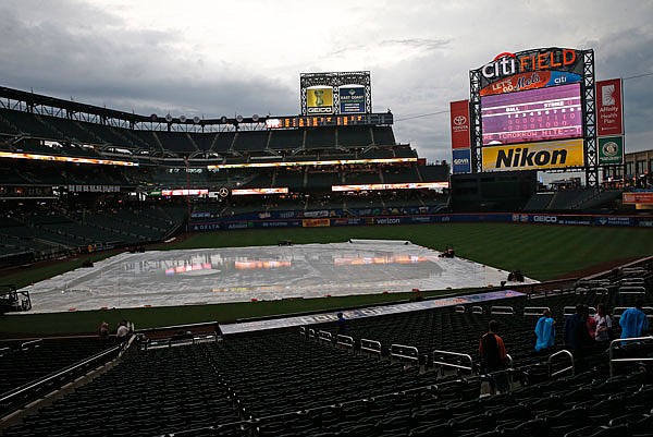 A tarp covered by rain sits on the field Monday night prior to the scheduled game between the Cardinals and the Mets at Citi Field. The game was called off and will be made up as part of a doubleheader today.