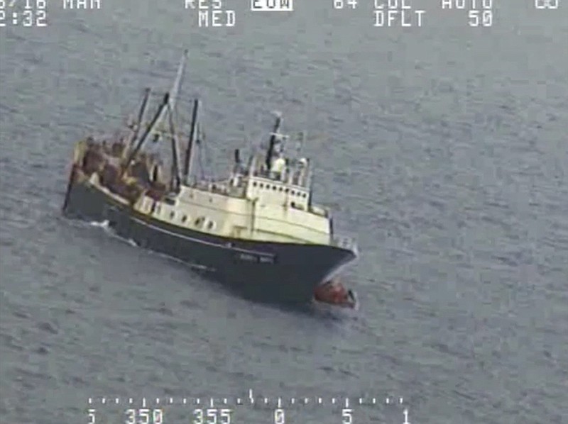 Crew from a sinking fishing boat, left, board life rafts off Alaska's Aleutian Islands on Tuesday in the Bering Sea.