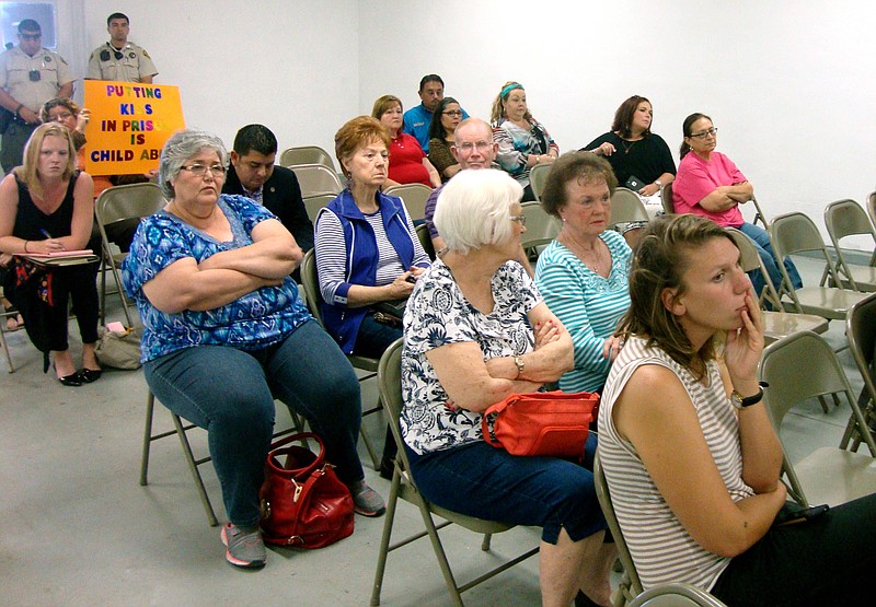 Residents of Jim Wells County, Texas, listen to comments during a public meeting about a proposal to turn an abandoned nursing home into a family immigrant detention center. 