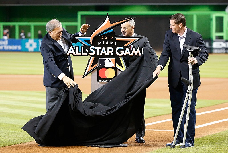 Jeffrey Loria, left, owner of the Miami Marlins, Robert Manfred Jr., commissioner of baseball, and Jeff Conine, special assistant to the president of the Marlins, unveil the official logo for the 2017 All-Star Game that will be held in Miami, during a ceremony before the start of a baseball game between the Miami Marlins and the Philadelphia Phillies, Wednesday, July 27, 2016, in Miami. 