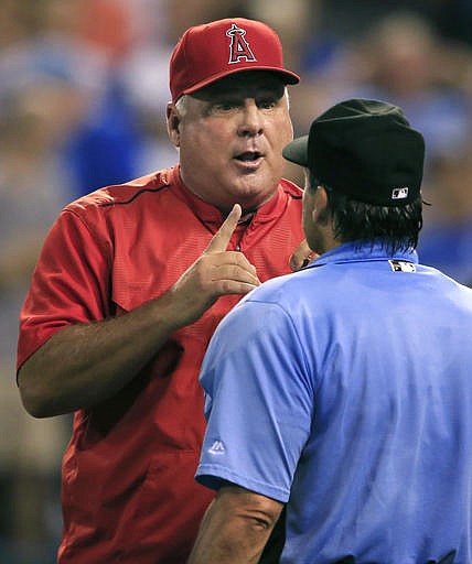 Los Angeles Angels manager Mike Scioscia, back, questions home plate umpire Phil Cuzzi during the seventh inning of a baseball game against the Kansas City Royals at Kauffman Stadium in Kansas City, Mo., Wednesday, July 27, 2016. 