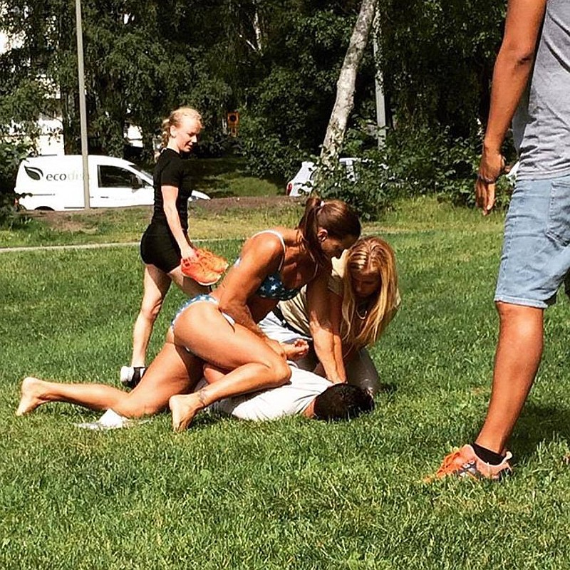 In this photo provided by Jenny Kitsune Adolffson, Swedish police officer Mikaela Kellner pins a man to the ground who is suspected of stealing a friend's mobile phone Wednesday, July 27, 2016, in Stockholm, Sweden. She was off duty and wearing a bikini, but that didn't stop her from apprehending the man. 