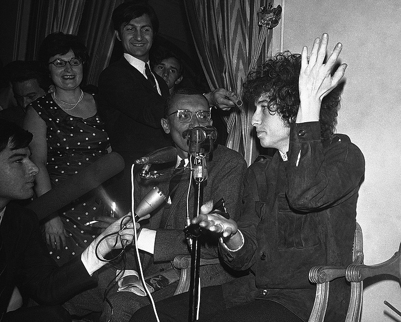 In this May 22, 1966 file photo, Bob Dylan gestures during a press conference in Paris, France. Dylan's tumble from his Triumph in Woodstock, N.Y., 50 years ago on July 29, 1966, was the most analyzed motorcycle crash in pop-culture history. But for all its importance, details surrounding the crash remain foggy.