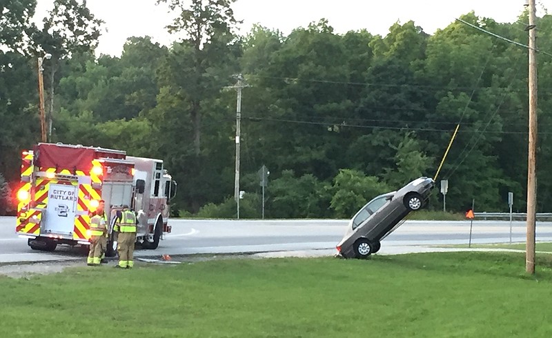 This Wednesday, July 27, 2016, photo provided by G. Ray Ault shows a vehicle on wires attached to a utility pole in Mendon, Vt. Police in Vermont say the car ended up almost vertical when the driver swerved quickly in response to her GPS ordering her to "turn around."