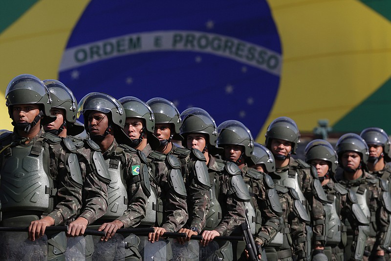In this July 22, 2016 photo, Brazilian Army soldiers take part in military exercise during presentation of the security forces for the Rio 2016 Olympic Games, in front of the National Stadium, in Brasilia, Brazil. Security has emerged as the top concern during the Olympics, including violence possibly spilling over from Rio's hundreds of slums. Authorities have said 85,000 police officers and soldiers will be patrolling during the competitions.