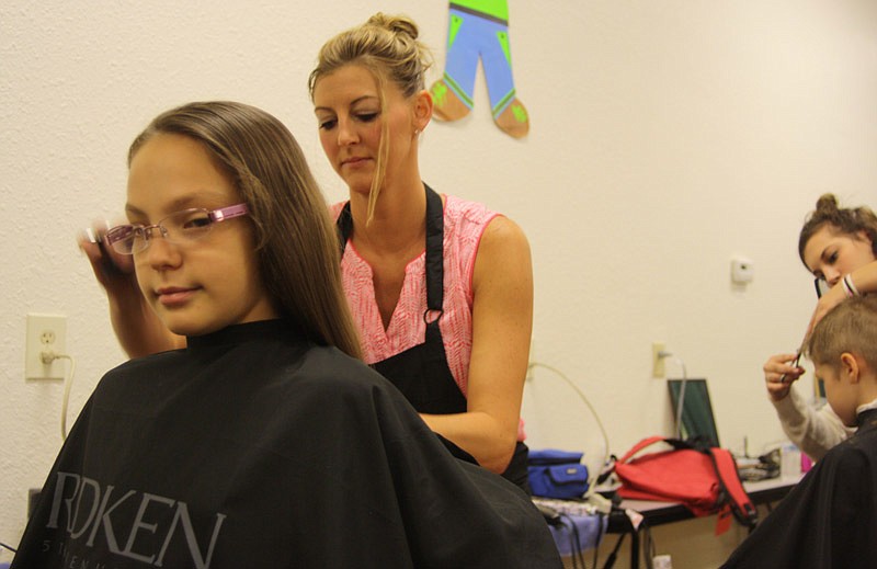 Khrystie Wulff, 11, gets a hair cut at the SERVE, Inc.'s Back-to-School Fair at Callaway Christian Church in Fulton on Saturday, July 30, 2016.