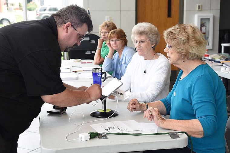 Chad Tharpe records his signature electronically in view of the election judges Tuesday at the Miller Performing Arts Center polling location. Seated from right are Janice Webb, Mary Ellen Budnik, Margie Steinmetz and Garnet Day. Day and Webb served as election supervisors for the day's primary election voting.