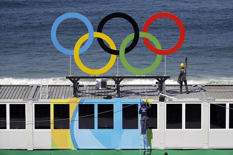 Workers install Olympic rings with the ocean as a backdrop Friday, Aug. 5, 2016, during a training session at Copacabana beach volleyball arena at the 2016 Summer Olympics in Rio de Janeiro, Brazil.