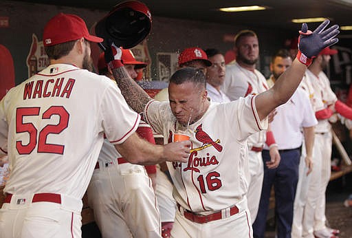 St. Louis Cardinals' Kolten Wong (16) gets a face full of water from teammate Michael Wacha (52) after hitting a solo home run in the fifth inning of a baseball game against the Atlanta Braves, Saturday, Aug. 6, 2016, in St. Louis.