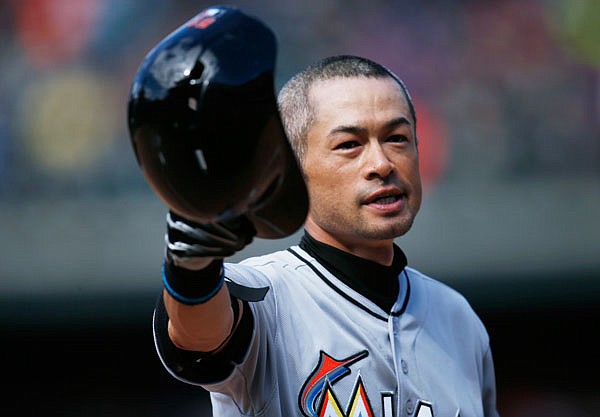Ichiro Suzuki of the Marlins tips his batting helmet to the crowd as fans applaud after he hit a triple off Rockies relief pitcher Chris Rusin for his 3,000th career hit Sunday in Denver.