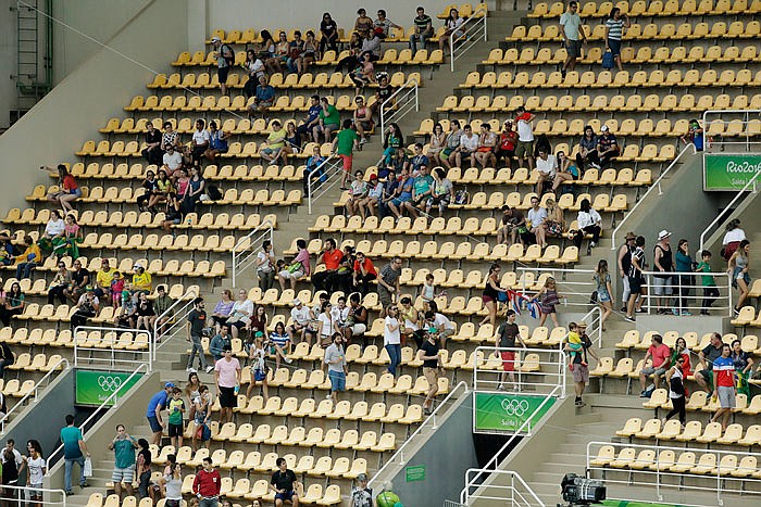 Spectators move from where they were sitting at the far end of the arena towards the diving pool end to fill empty seats at the start of the women's synchronized 3-meter springboard diving final at the Olympics in Rio.