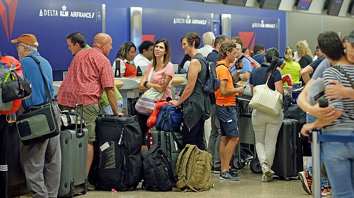 Passengers stand in line after Delta Air Lines flights resumed Monday in Salt Lake City, following a computer outage. Delta Air Lines delayed or canceled hundreds of flights Monday after its computer systems crashed, stranding thousands of people on a busy travel day. 