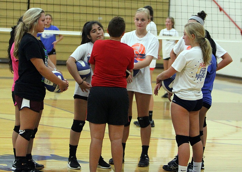 Players get a quick lesson during Monday's volleyball practice.