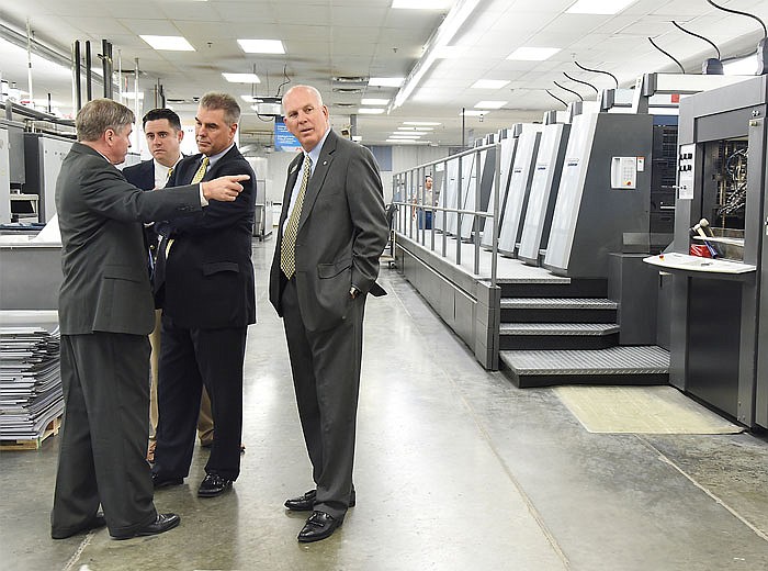 Greg Meeker, left, talks to representatives of Central Bank who were at Modern Litho  Monday morning for two announcements. Meeker is vice president of sales and marketing for MLP and talking to Clay Broughton, David Minton, middle and Terry Higgins, about the expansion the local print facility is about to undergo. 