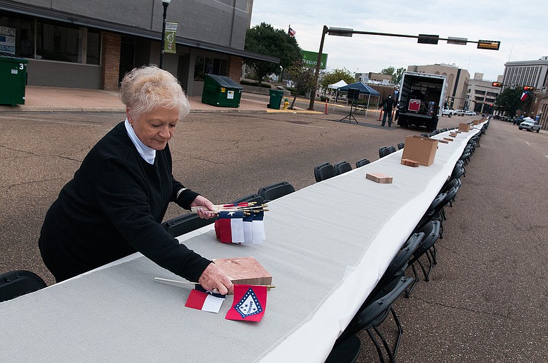 Ann Treadway lays out state flags for Arkansas and Texas while preparing for the first Dine on the Line event Friday, Oct. 30, 2015, on North State Line Avenue.