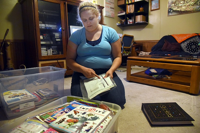 Heather Cornelison sits in front of her sticker collection in her home. Cornelison is trying to get the world record for largest sticker collection. She has more than 102,000 stickers.