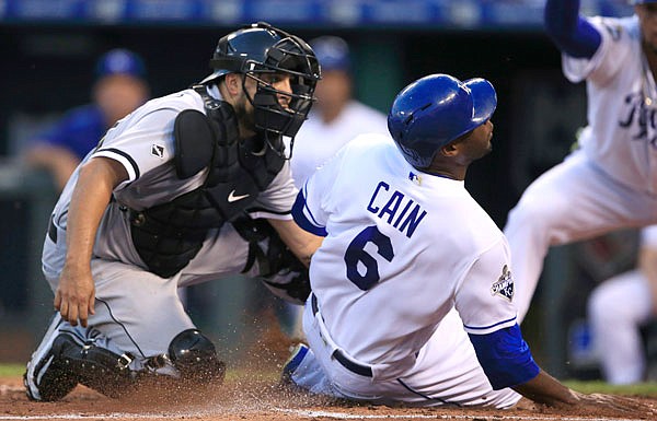 Royals center fielder Lorenzo Cain (right) beats the tag by White Sox catcher Dioner Navarro (left) during the third inning of Tuesday night's game in Kansas City.