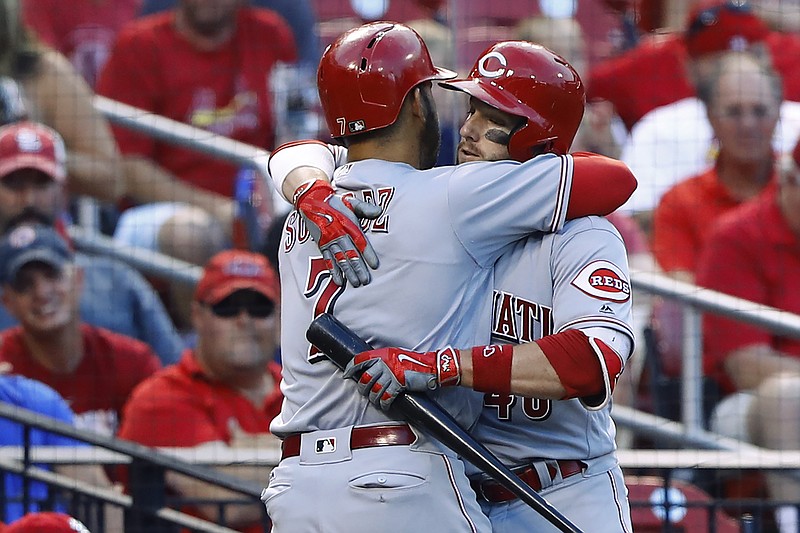 Cincinnati Reds' Eugenio Suarez, left, is congratulated by Tyler Holt after hitting a home run off of St. Louis Cardinals starting pitcher Jaime Garcia during the fourth inning of a baseball game, Wednesday, Aug. 10, 2016, in St. Louis. 