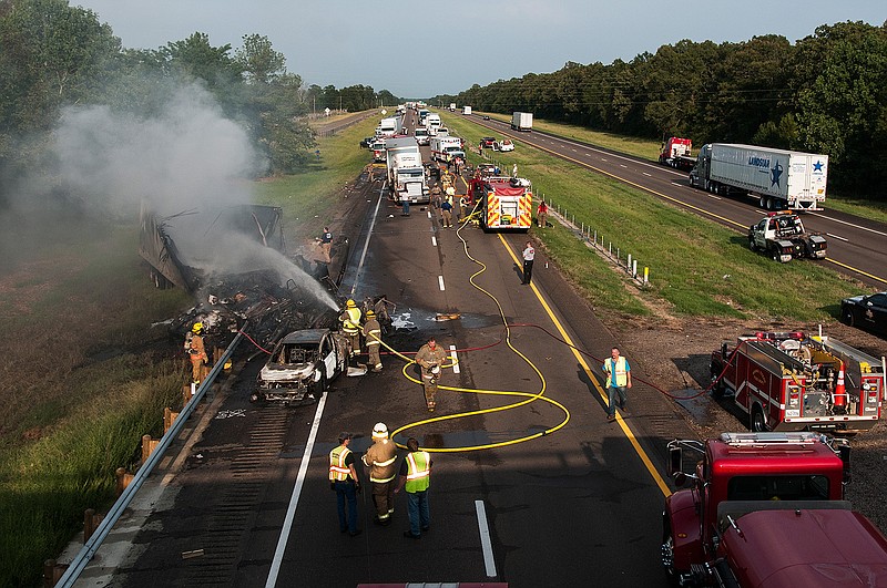 Area firefighters and emergency personnel work with Texas Department of Public Safety troopers and other law enforcement at  the scene of a multi-vehicle crash Thursday afternoon, Aug. 11, 2016 on Interstate 30 east of New Boston, Texas. One driver was killed.