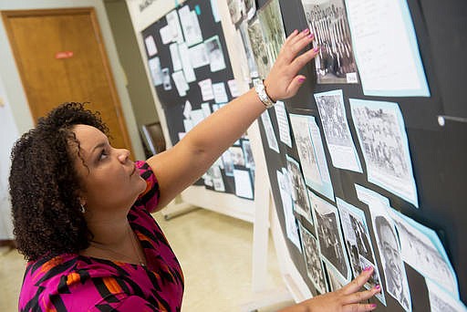 In this Aug. 5, 2016 photo, Dola Flake arranges photographs of Joplin's black community for an exhibit at the Joplin Community Center in Joplin, Mo.. (Roger Nomer/The Joplin Globe via AP)