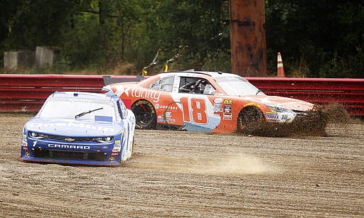 Elliott Sadler (1) and Owen Kelly (18) slide off track during the NASCAR Xfinity Series auto race at Mid-Ohio Sports Car Course Saturday, Aug. 13, 2015 in Lexington, Ohio.