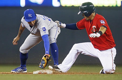 Minnesota Twins' Kurt Suzuki, right, beats the tag by Kansas City Royals second baseman Raul Mondesi for a double during the third inning of a baseball game Friday, Aug. 12, 2016, in Minneapolis. 