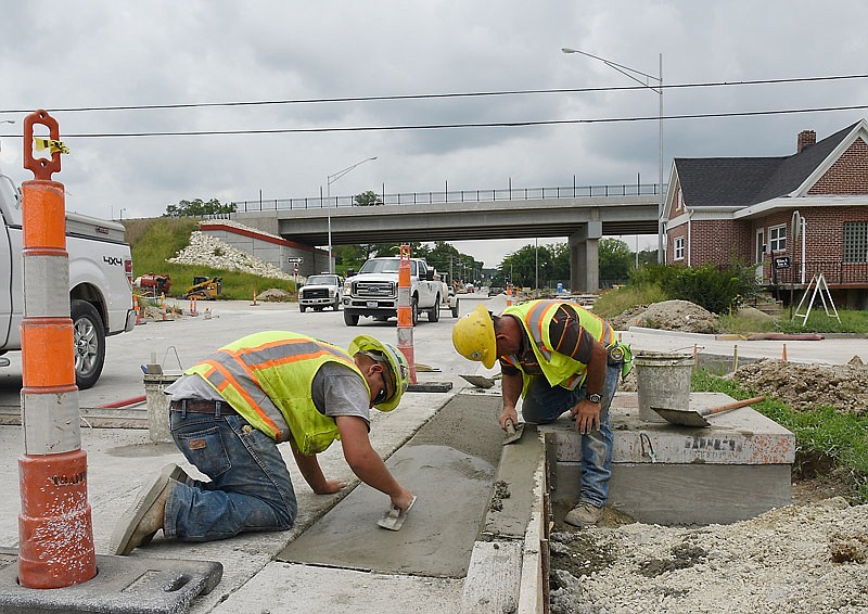 Brocke Lunceford, left, and Phillip Divine apply the finishing touches to the concrete curbing on
Lafayette Street Friday afternoon, Aug. 12, 2016. Both work for Emery Sapp and Sons in Columbia and are part of the crew on the Lafayette Street interchange project. They are busy making the connectors, as they are about to wrap up the nearly two-year project.