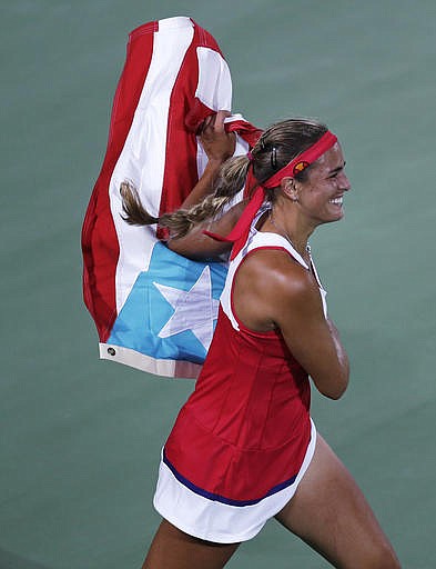 Monica Puig, of Puerto Rico, celebrates after winning the gold medal against Angelique Kerber, of Germany, during the final round at the 2016 Summer Olympics in Rio de Janeiro, Brazil, Saturday, Aug. 13, 2016.