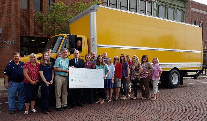 Holding a $5,000 check from the bank are, from left, Steve Mallinckrodt, SERVE Inc.'s executive director; Rick Gohring, market president of the Callaway Bank; Kim Barnes, president and CEO of the bank; and Brittany Lenhart, food pantry manager. In the driver's seat is Bryant Liddle, of SERVE.