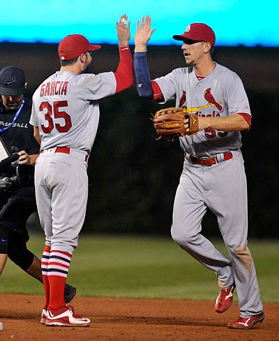 Stephen Piscotty (right) celebrates with Cardinals teammate Greg Garcia after Sunday night's 6-4 win against the Cubs in Chicago.