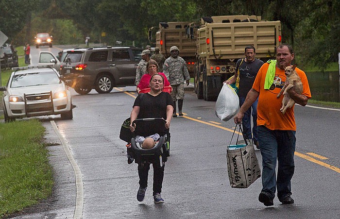 People arrive to be evacuated by members of the Louisiana National Guard near Walker, Louisiana, on Sunday.